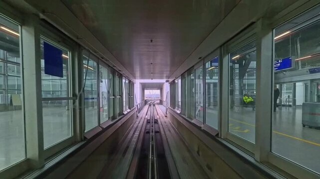 Point of view shot of airport people mover arriving at station