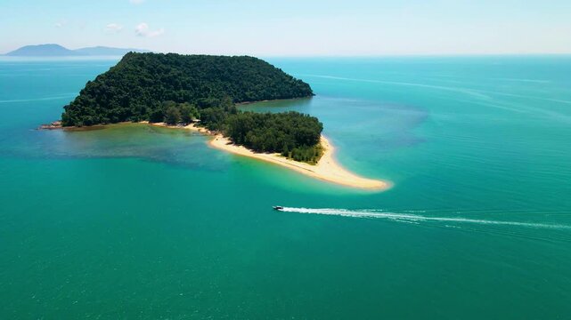 Aerial view of a small tropical island located just off the coast of Pantai Bukit Keluang in Besut, Terengganu. The island is covered in dense green forest and surrounded by vibrant turquoise waters.