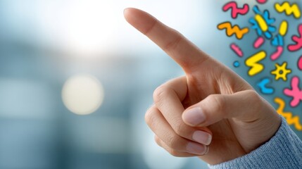 A close-up of a woman's hand pointing upward, symbolizing ideas and creativity against a bright, abstract background.