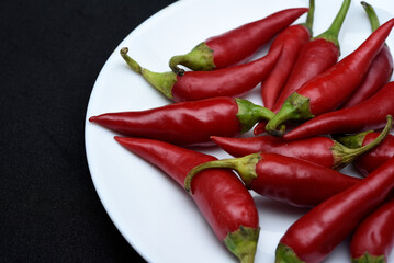 Red capsicum on a white plate. Red pepper pods.