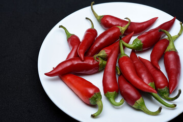 Red capsicum on a white plate. Red pepper pods.