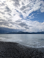 Tranquil Beach with Pebbles and Blue Sky Under Clouds