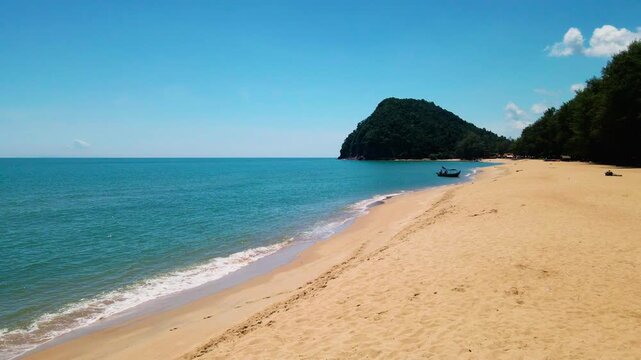 Aerial view of Pantai Bukit Keluang, Besut, Terengganu, showing turquoise waters, coastal cliffs, and clear sunny skies along the scenic shoreline.