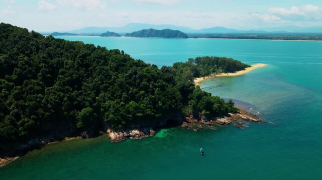 Aerial view of Pantai Bukit Keluang, Besut, Terengganu, showing turquoise waters, coastal cliffs, and clear sunny skies along the scenic shoreline.