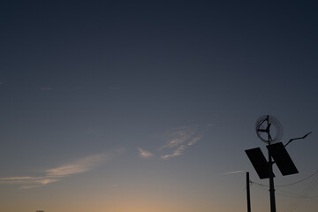Pre dawn sky with jet contrails in the sky and a wind measurement turbine