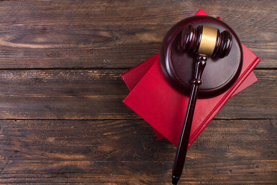 Law concept - Open law book with a wooden judges gavel on table in a courtroom or law enforcement office isolated on white background. top view.