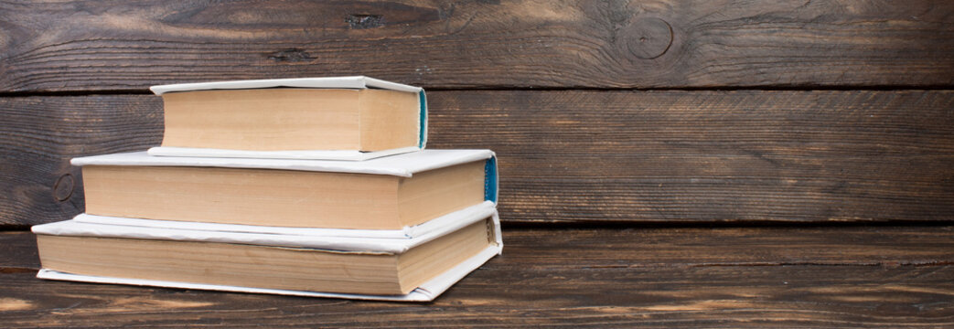 Stack of white books. Education background. Back to school. Book, hardback books on wooden table. Education business concept. Copy space for text. panorama, banner.