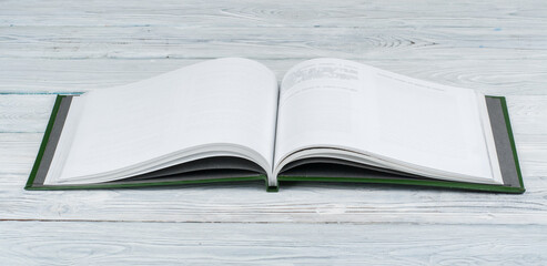Open book on wooden deck table and black board background. Back to School. Education concept with copy space for your ad text.
