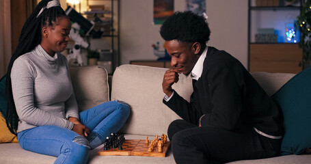 In the evening after classes, two students of multi-racial background sit on a sofa in the living...