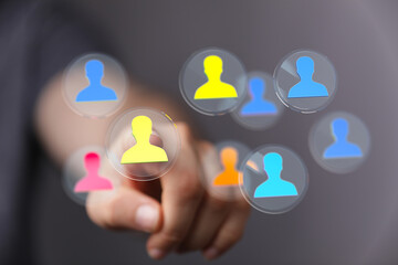 Hand pointing at colorful digital people icons, representing teamwork, communication, and connectivity in a global digital world. Ideal for busi