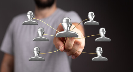 Visual representation of connection, networking and teamwork. A man's hand interacting with connected human figure icons. Illustrating concepts