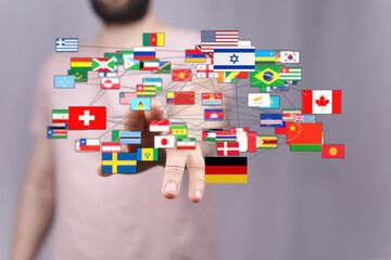 Conceptual image of a person touching connected world flags, representing global connections,...