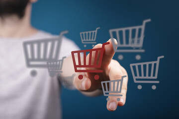 Person interacting with shopping cart icons representing online shopping and purchases, symbolizing...
