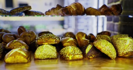 A warm display showcases an array of artisanal baked goods in a charming bakery. Golden crusts and enticing aromas fill the air, inviting customers to indulge in sweet and savory delights.