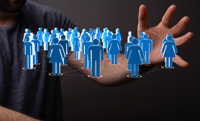 Concept of social network and connected community through a hand holding blue figures on a dark...