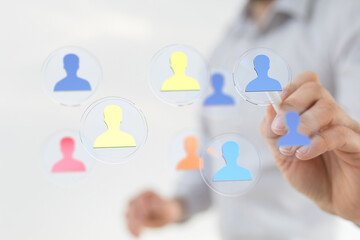 Abstract image of a person touching icons representing people, emphasizing network, teamwork, and connectivity in business.