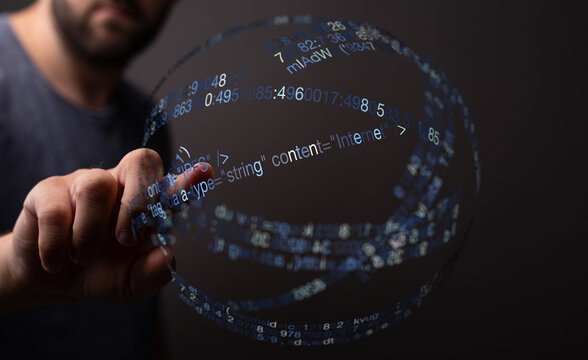 A close-up of a hand pointing towards a glowing sphere of code. Represents technology, data, innovation, and digital transformation i - Powered by Adobe