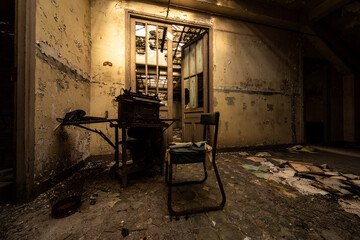 Sunlit abandoned office with vintage typewriter and worn chair in a decaying interior