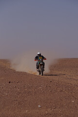 Rally Motorcycle Rider Charging Across the Algerian Desert Kicking Up Dust