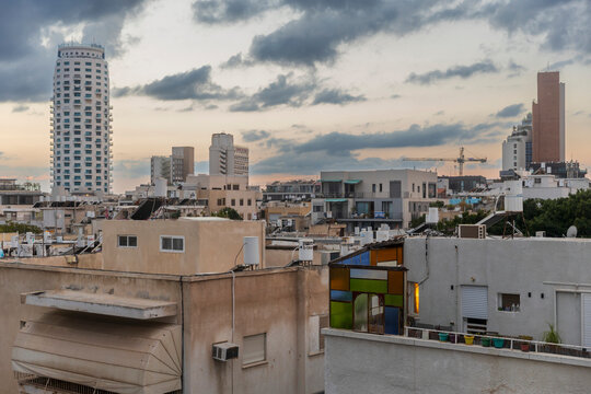 Tel Aviv, Israel, 6 November, 2025, Elevated view of Tel Aviv neighborhood with low-rise buildings and modern high-rises under overcast dusk sky.