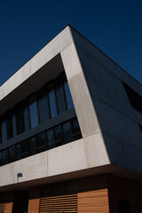 Minimalist Modern Office Building Corner with Concrete Facade and Wood Slat Base