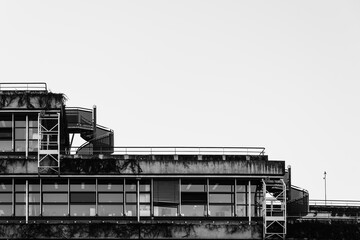 Minimalist Black and White Photo of Modern Concrete Building with Spiral Staircase and Rooftop Terrace