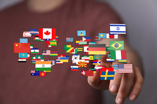 Man pointing to international flags, representing globalization, connection, and diversity. A conceptual image for international collaboration, - Powered by Adobe