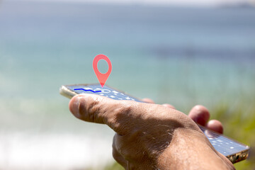 Hand holding smartphone displaying geolocation pin on screen