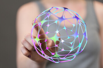 Close-up of a hand holding a glowing 3D geometric sphere. The image represents connectivity, technology, and global networks. Perfect