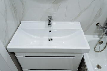 elegant modern bathroom, contemporary marble vanity styling, sleek white ceramic basin with chic fixtures, charming bathroom interior showcasing polished surfaces and metallic accents