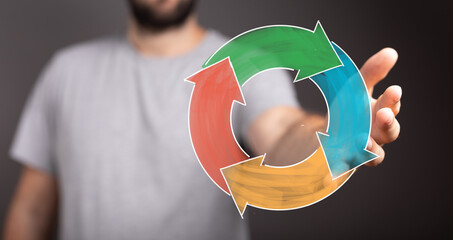 A man's hand offers a colorful circular flow diagram symbolizing processes, ideas, and strategies. Perfect for business, marketing, or concept i