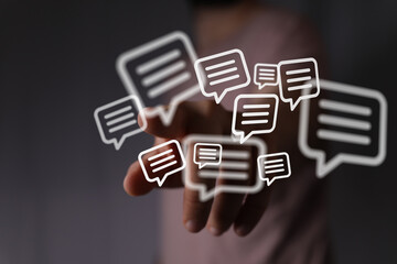 Abstract image of a hand interacting with digital message bubbles. Represents communication, technology, and social media.