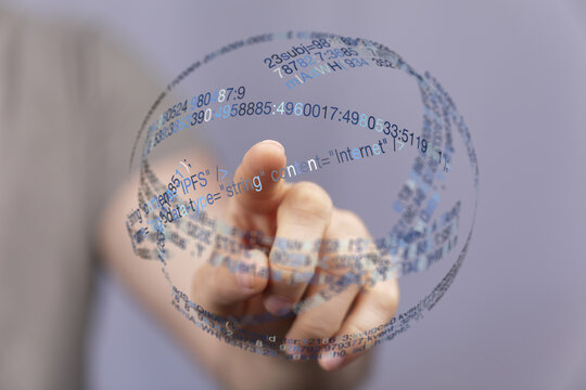 A hand touching a transparent digital globe with code, symbolizing connection, technology, the internet, and data. Modern concept for