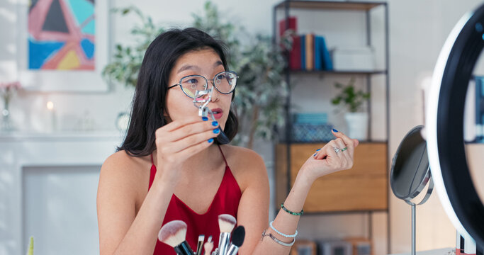 A smiling influencer shares her beauty tip for perfect lashes, holding up an eyelash curler and explaining the technique step by step.