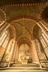 Fototapeta premium Sunlit Abandoned Monastery Interior with Striped Brick Vaults and Ornate Altar