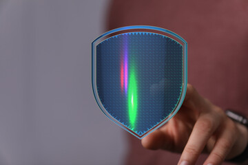 A hand touches a glowing digital shield, representing data protection, cyber security, privacy, and technology. Ideal for illustratin
