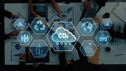 A diverse group of professionals engaged in a strategy meeting focuses on sustainability, analyzing CO2 emissions data through digital graphics and visual aids. Raster - Powered by Adobe