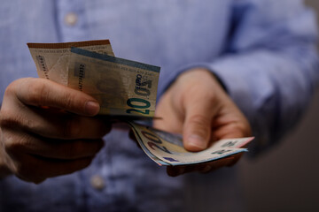 Close-up of a person counting twenty euro banknotes. Financial concept, wealth management, and economic themes are highlighted.