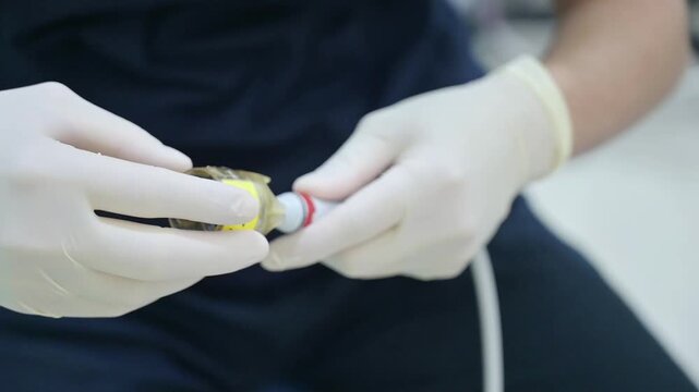 The dentist is assembling the high-volume evacuator by attaching the disposable suction tip to the filter housing