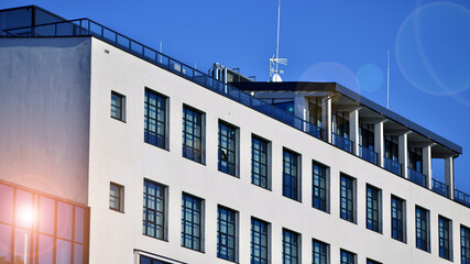 Office building in loft style. Facade of commercial office with windows. White walls of an...