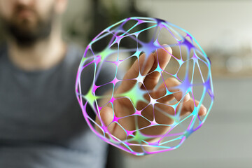 Close-up of a person's hand holding a glowing digital sphere. The image represents the concepts of technology, data, and connectivity