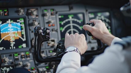 Male captain's hands holding the control yoke, flying a modern passenger aircraft with the autopilot engaged during a commercial flight while navigating through the flight deck instruments