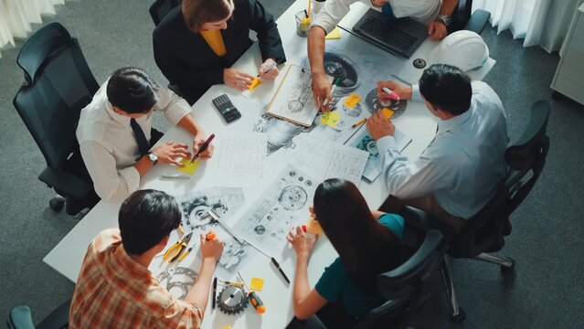 Group of diverse team planning strategy while sitting at table with project plan. Top aerial view of smart business people working together to brainstorm and design house construction. Alimentation.