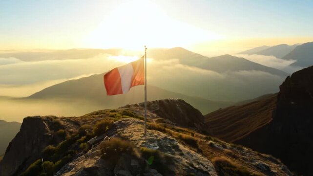 Peruvian flag flying high on a mountain peak at golden sunrise