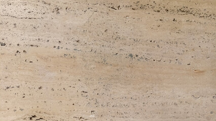 Texture of a light cream-colored wall or ground surface with many pores and small pebbles.