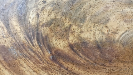 Natural wood texture with circular grain patterns in dark and light brown.
