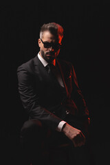 Obraz premium Serious man in sunglasses posing on chair