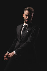 Fototapeta premium Mysterious man in suit sitting with hands in front