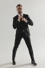 Handsome man posing and adjusting his tie