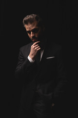 Pensive man posing with hand on chin